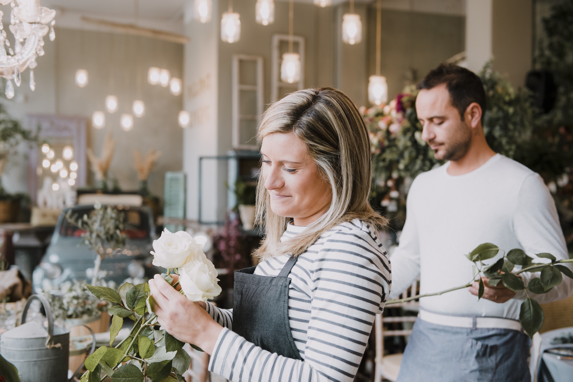 Two florists in flower shop, arranging flowers
